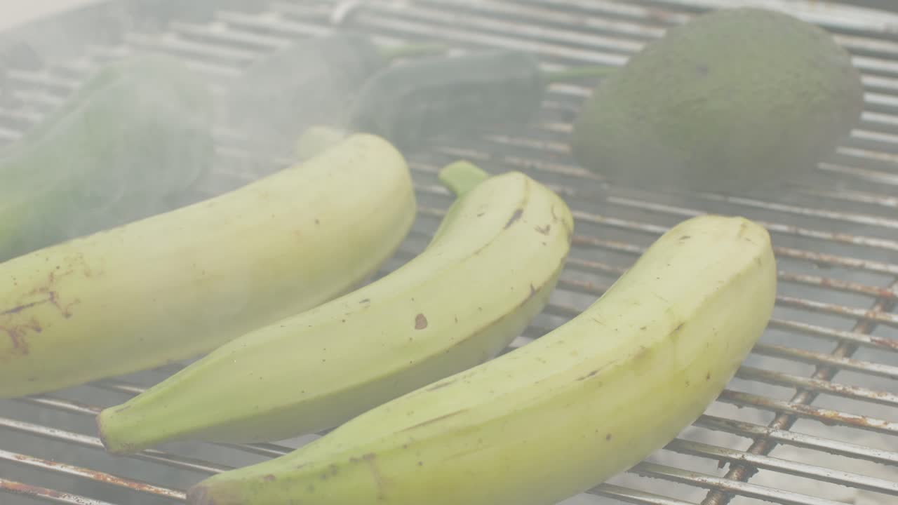 Grilled Banana on fire, latin american vegan grill with avocado and pepper, thai or Ecuadorian Street food. African traditional food on grill.