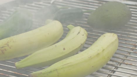 grilled banana on fire, latin american vegan grill with avocado and pepper, thai or ecuadorian street food. african traditional food on grill.