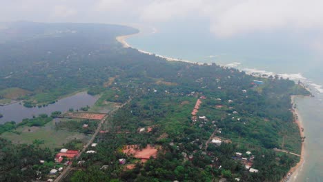 aerial, drone shot over a paradise coast, zoom in above trincomalee city, on a cloudy day, in gokanna, in the eastern province of sri lanka