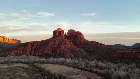 Aerial-view-approaching-Cathedral-Rock-in-Sedona-at-sunset-with-strong-red-hues