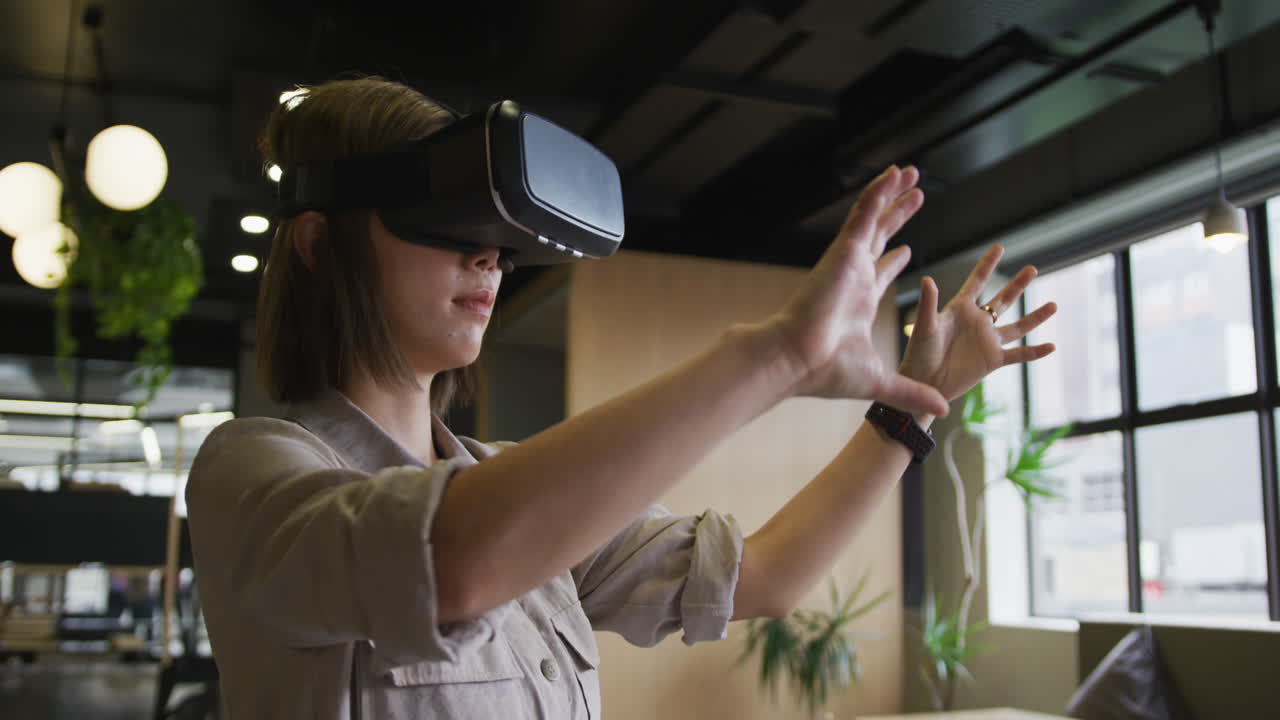 una mujer de negocios asiática de pie usando vr googles en una oficina moderna