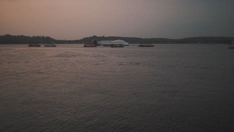 Una-Toma-De-Establecimiento-Con-Vistas-Al-Hermoso-Río-Mahadayi-Al-Atardecer,-A-Lo-Lejos-Los-Barcos-Y-Embarcaciones-De-Pesca-Locales-Permanecieron-Anclados-Durante-La-Noche,-Goa,-India