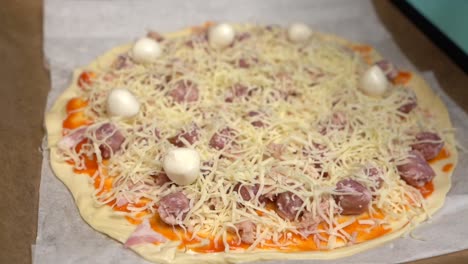 hand placing mozzarella cheese balls on homemade pizza