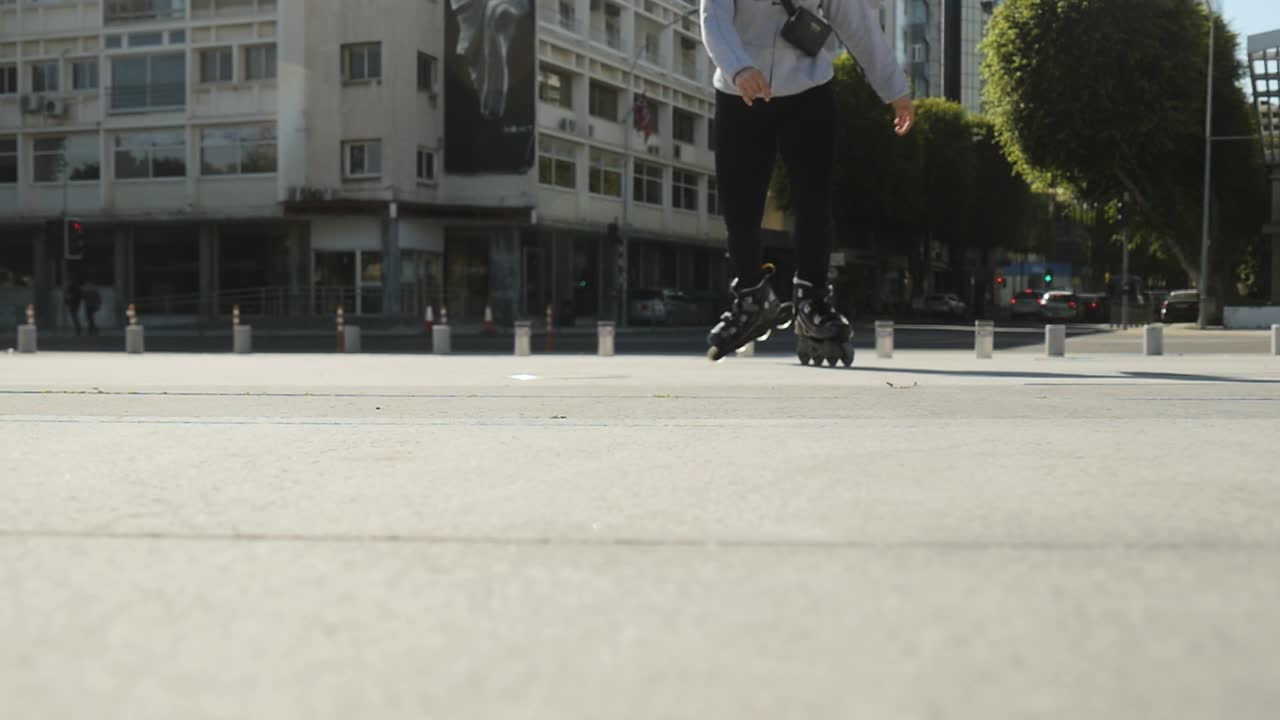 Skating on a downtown sidewalk. Creative low angle perspective as a rollerblader skates towards and over the camera.