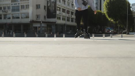 skating on a downtown sidewalk. creative low angle perspective as a rollerblader skates towards and over the camera.