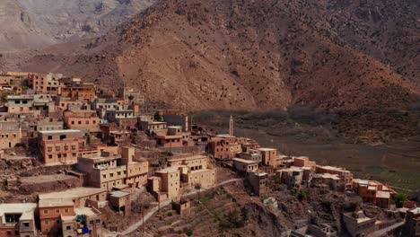 aerial drone view of a remote rural moroccan village located on the high atlas mountains in morocco.camera flying around the village unveiling different prospectives.