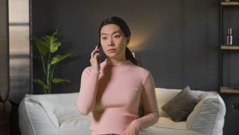 woman indoors at home in lounge talking on mobile phone 1