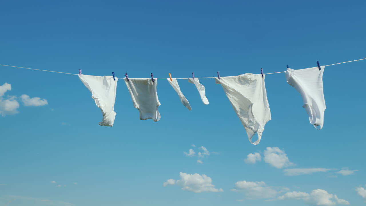 하얀색 리넨은 푸른 하늘 배경 4k 비디오에 밧줄로 말린다