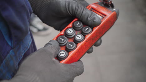 factory worker operating industrial lifting machinery with controller, closeup