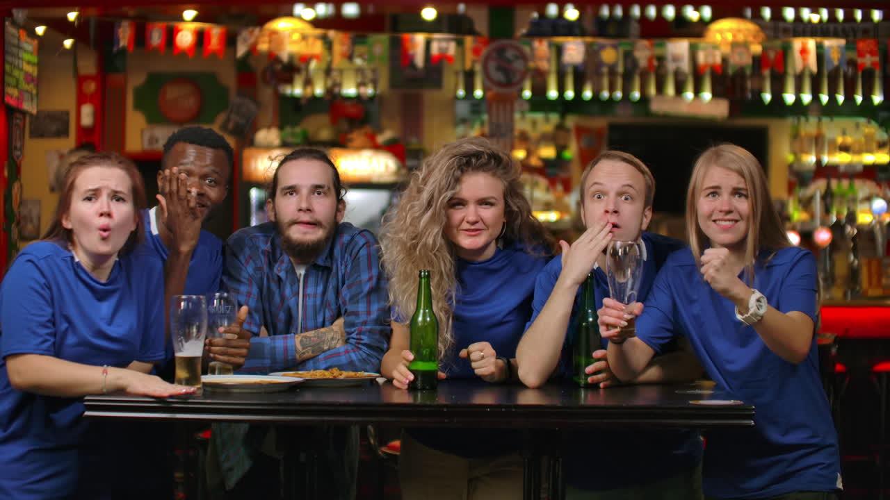 il piano generale è un piano per i tifosi che stanno vivendo un momento decisivo dinamico e poi si rallegrano della vittoria della loro squadra. i tifosi celebrano la vittoria al loro bar della squadra.