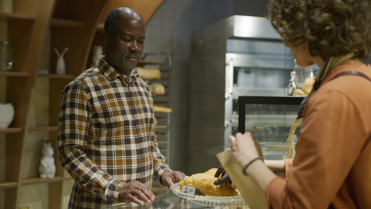 Customer Buying Croissants at a Bakery