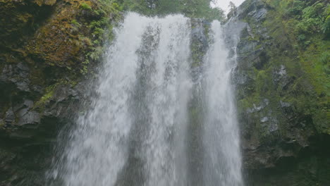face of cliff worn smooth by water of falls creek falls in gifford pinchot national forest, low angle static view.