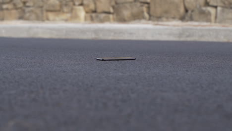 car tires driving over mobile smart phone gorilla glass on normal road with tarmac - wide angle