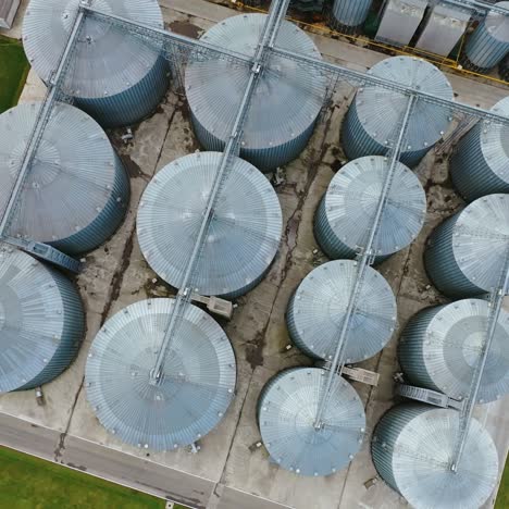 large metal granaries. agriculture manufacturing plant . agriculture grain silos storage tank. grain elevator on factory. top aerial view.