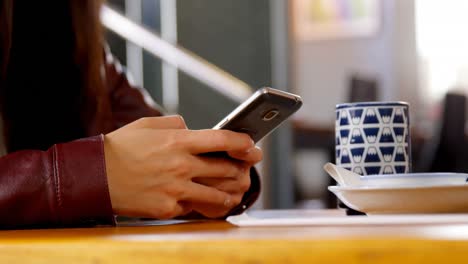 Woman-using-mobile-phone-at-restaurant-4k