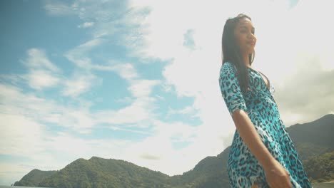 Modelo-Femenino-Caminando-Y-Vestidos-Que-Soplan-En-El-Viento-Con-Un-Paisaje-Nublado-épico-En-El-Fondo