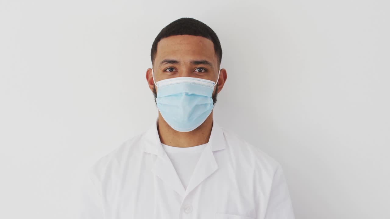 Male heath worker wearing face mask against white background