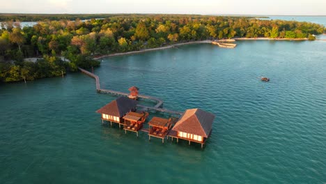 Zwei-Exotische-Überwasserbungalows-Mit-Sonnendecks-Und-Langem-Pier,-Der-Die-Villen-Mit-Der-Insel-Leebong-Verbindet,-Belitung,-Indonesien---Luftparallaxe