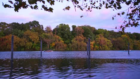 establecimiento de una toma amplia de personas remando en el río al atardecer