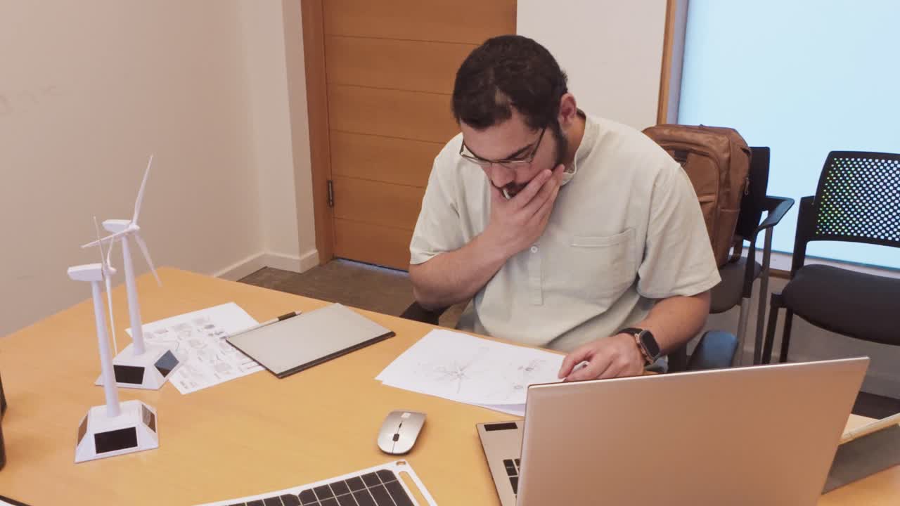 Thoughtful Young Architect Contemplating a Design at His Desk