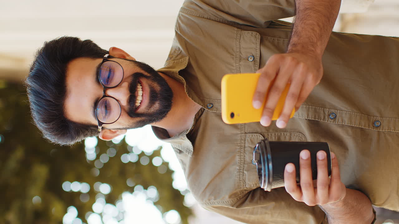 Young adult man use smartphone typing text messages browsing internet finishing work chatting online