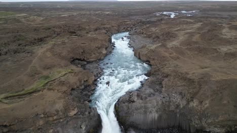 Luftaufnahme-Des-Aldeyjarfoss-Wasserfalls-Mit-Einem-20-Meter-Gefälle-In-Ein-Turbulentes-Becken-Mit-Basaltsäulen-In-Irland-Im-Sommer