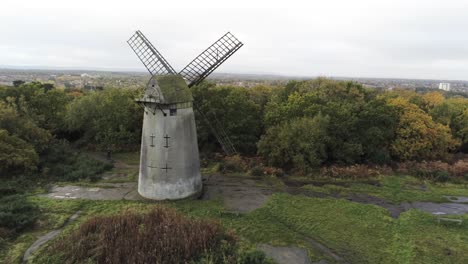 Traditionelle-Holzmühle-Windmühle-Aus-Stein-Erhalten-Im-Herbst-Wald-Luftbild-Landschaft-Linke-Umlaufbahn