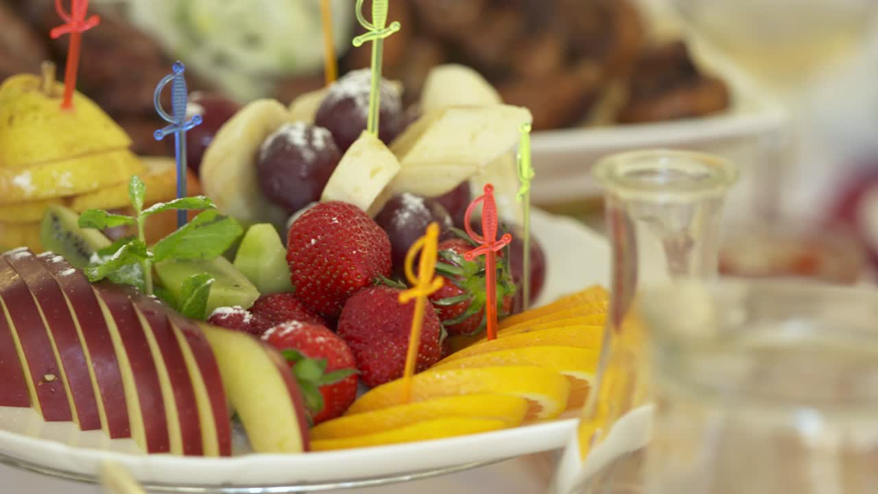 축제 저녁 식탁에 신선한 과일 접시. 다양한 잘라진 과일 스피어