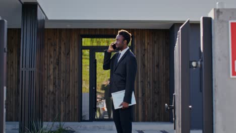 real estate agent talking on phone at modern house