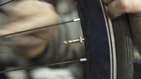 a bicycle mechanic inflating a tire with an air compressor