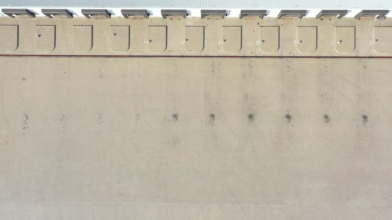 vista aérea de camiones semirremolques parados en las rampas del almacén para cargar y descargar mercancías en el parque logístico