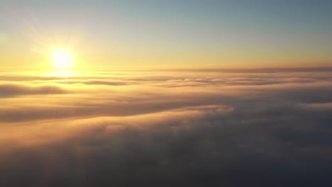 cinematic and atmospheric clip of sun above layer of soft clouds at sunrise