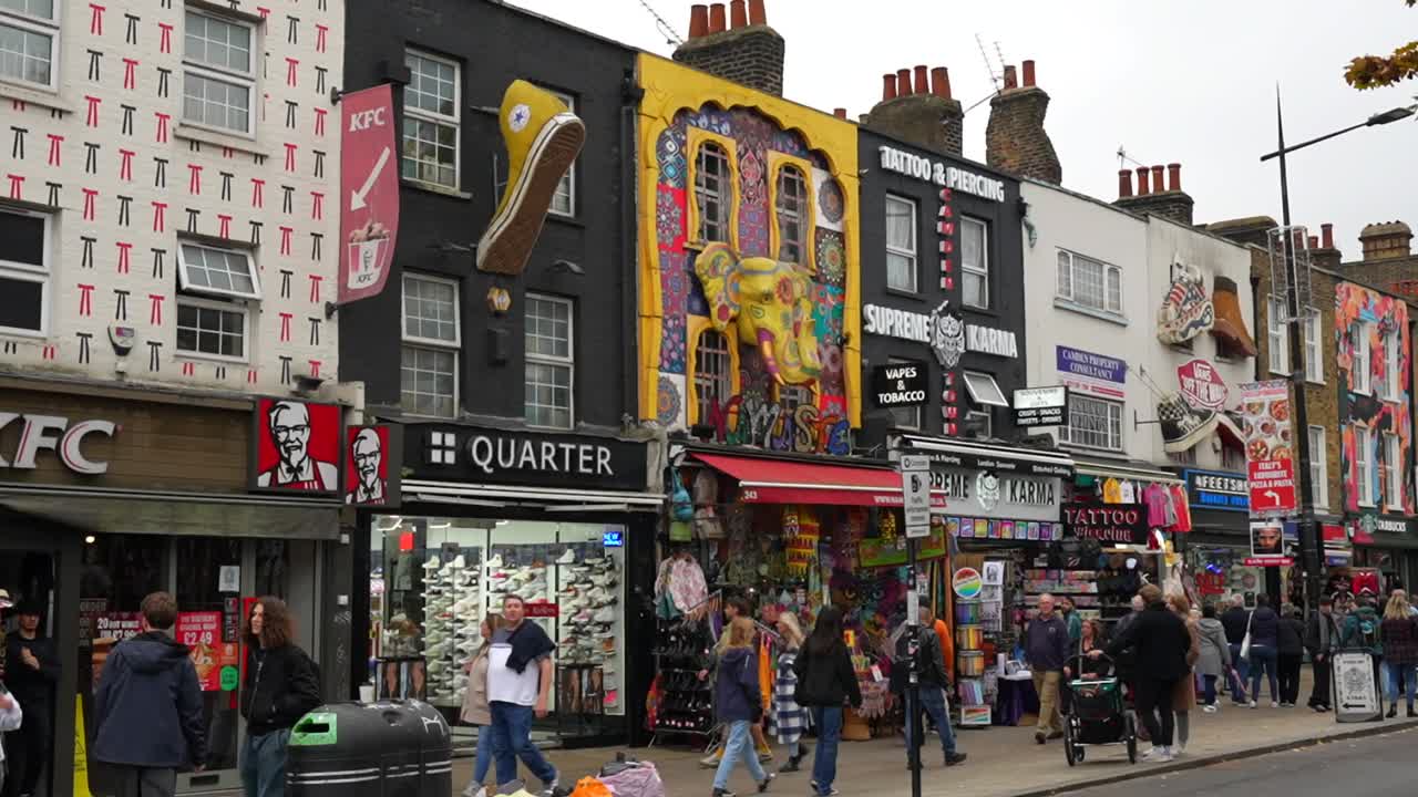 Visitors explore Camden Town in London with vibrant storefronts and colorful street art