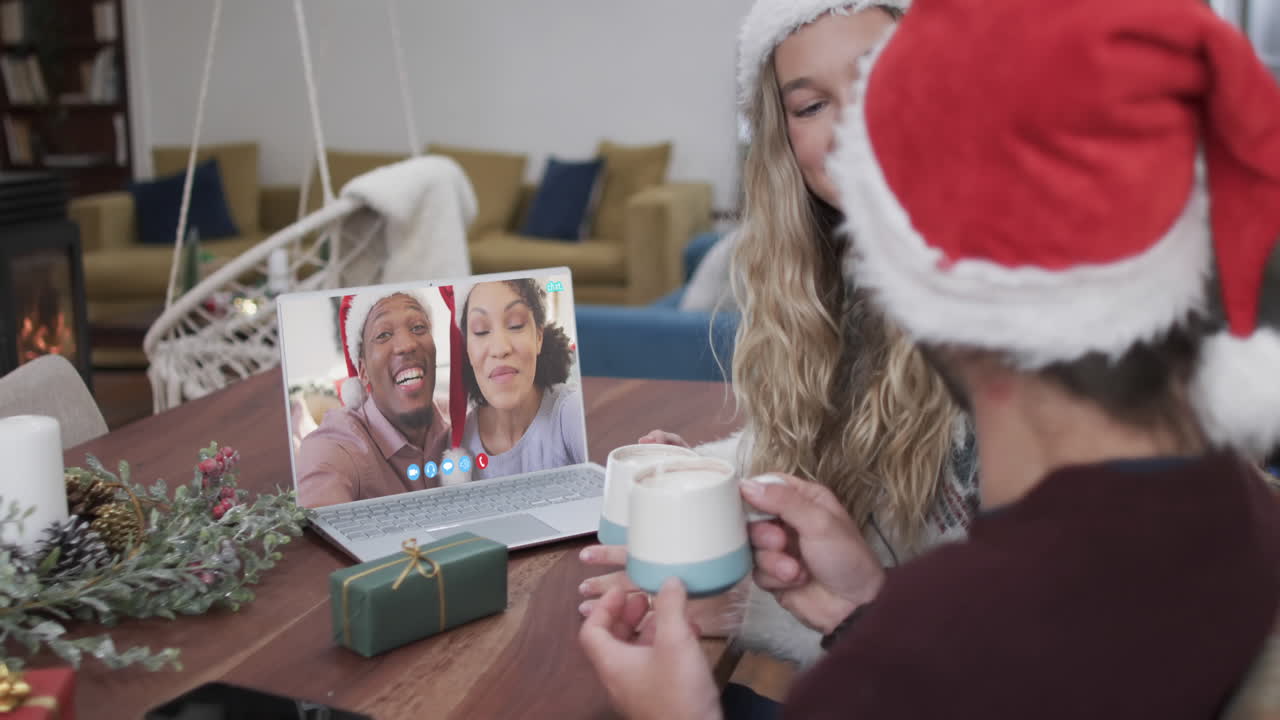 dos parejas felices y diversas teniendo una llamada de video de laptop de navidad, en cámara lenta