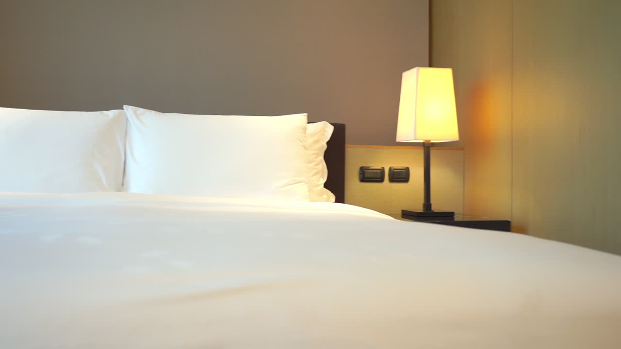 Tempat Tidur Putih Kosong di Kamar Tidur Dengan Lampu Tidur di Pagi yang Cerah, Pengambilan Gambar Panning