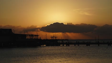 sunsetting behind the clouds over mobile bay, alabama