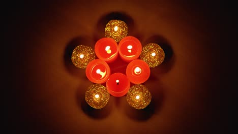 acérquese a una estrella navideña hecha con velas rojas y doradas