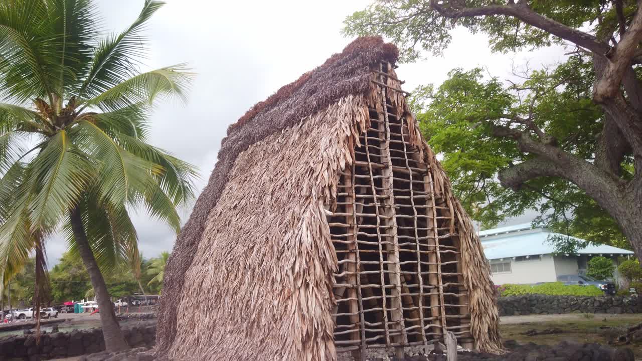 Gimbal booming down shot of an ancient Hawaiian hale at Pu'uhonua O Honaunau Historical National Park on the Big Island of Hawai'i