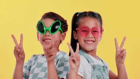 two kids wearing funny sunglasses making a peace sign