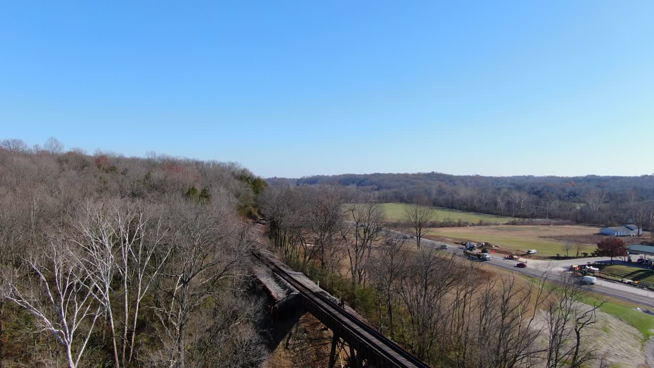 una toma aérea de las vías del ferrocarril que salen de un bosque y llegan al pope lick trestle en louisville, kentucky.