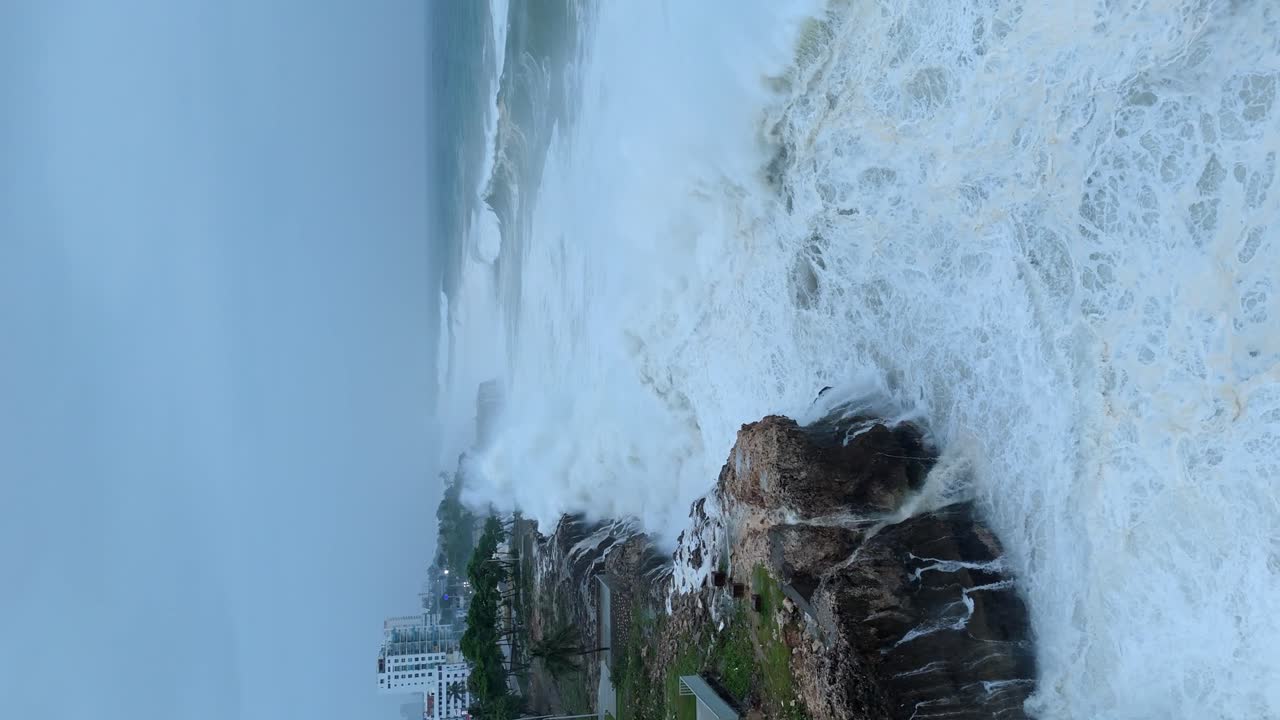 Vista drammatica da drone di onde che si infrangono e schizzano verso il cielo, Uragano Beryl.