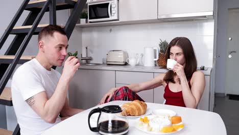 una pareja disfrutando del desayuno en la cocina.