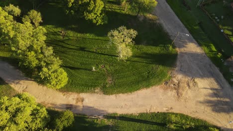 Vista-Aérea-Giratoria-Del-Jardinero-Cortando-Hierba-En-El-Parque