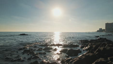 aerial view of sunny day moving over the rocky beach