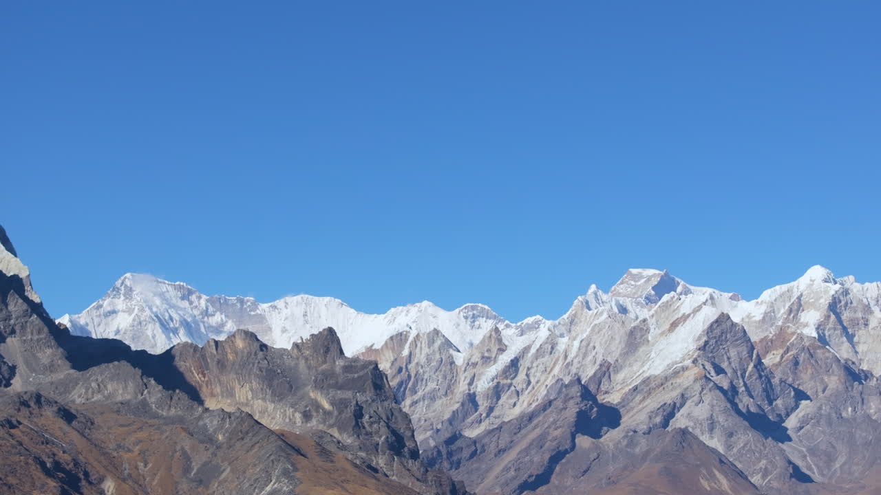 Panning aerial shot from Ama Dablam Base Camp revealing the Himalayan range, highlighting Cholatse, Everest, Nuptse, and Lhotse before settling on Mount Ama Dablam in Nepal