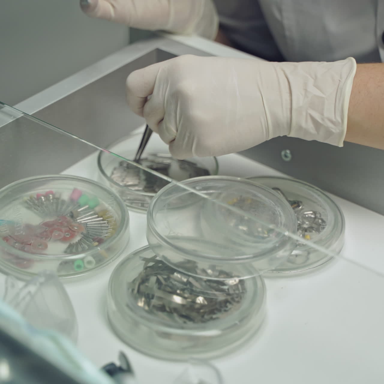 Selection of the instrument by the dentist for prosthetics on the table with a glass surface. Close-up. Modern dentistry.