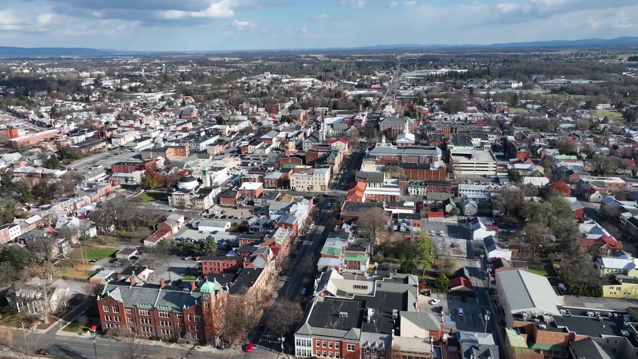 Översiktsbild från luften av en amerikansk stad med Main Street under en solig vinterdag. Historiska byggnader, bostadsområde och centrum. Vidvinkelbild i omloppsbana.