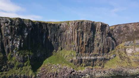 Aerial-rising-flying-towards-Kilt-Rock,-pan-right-revealing-cliffs-and-sea-waters,-Scotland