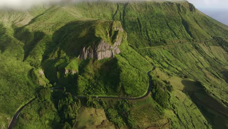 Vista-De-Drones-De-La-Montaña-Rocha-Dos-Bordões-Con-Conducción-De-Automóviles-En-Flores-Azores,-Aérea