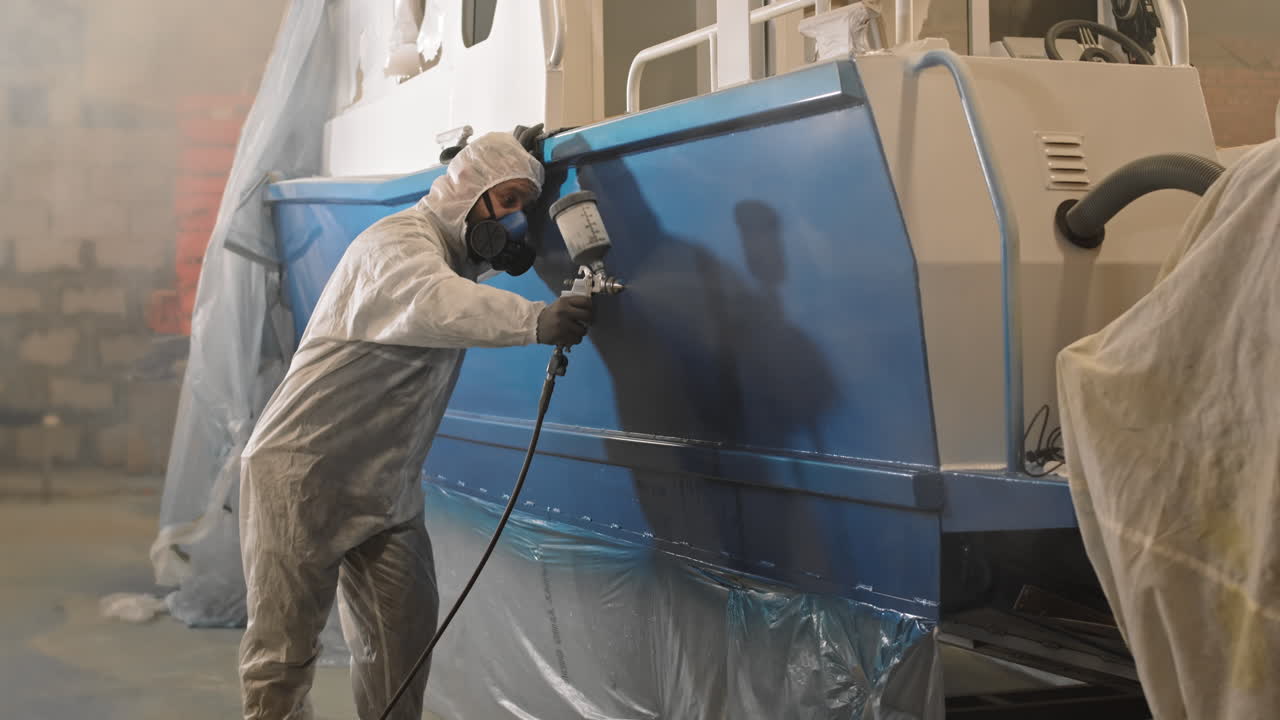 Workman Spraying Paint on Boat